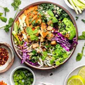 Overhead view of a vegan power bowl surrounded by bowls of individual ingredients