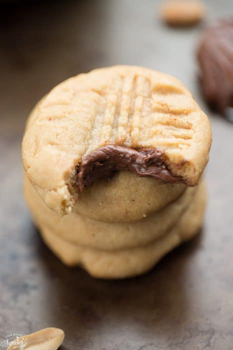Nutella Stuffed Peanut Butter Cookies in a stack with a bite out of the top one