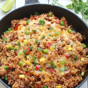 {One Pan} Mexican Rice Skillet - An easy Mexican rice dish made all in one pan in under 30 minutes. Perfect & easiest for weeknights with the best taco flavors. Even the rice made in same pan.