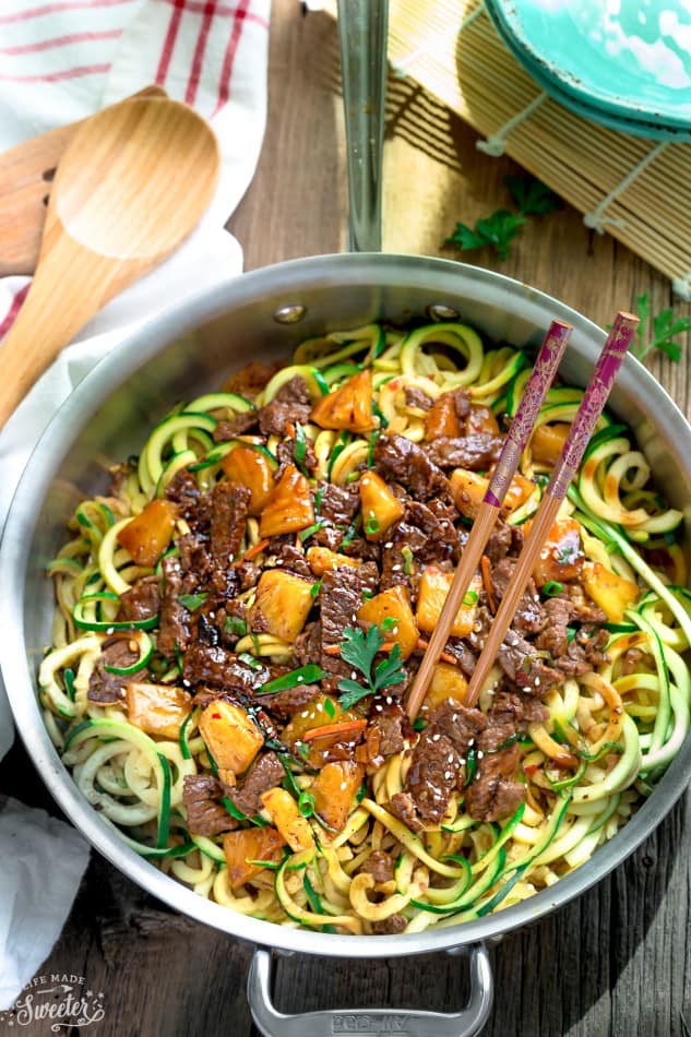 Top view of Mongolian Beef stir fried with zucchini noodles in a stainless steel pan with chopsticks