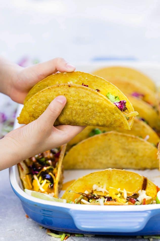 Baked Asian Sesame Chicken Tacos – a simple and delicious recipe perfect for busy weeknights and Cinco de Mayo. Best of all, a short recipe video. Layered with sweet and savory sesame chicken, rainbow vegetables, and a blend of 3 cheeses. Flavor packed and addicting!