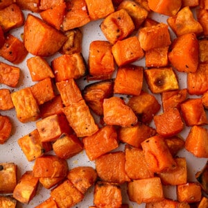 Cubed roasted sweet potatoes on a rectangle baking sheet