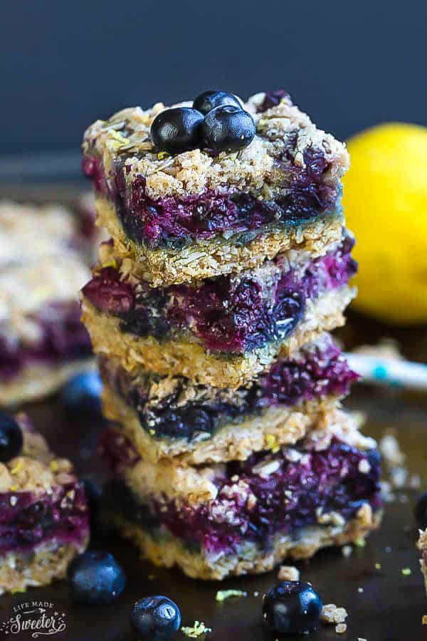 Front view of one stack of paleo blueberry crumble bars topped with fresh blueberries.