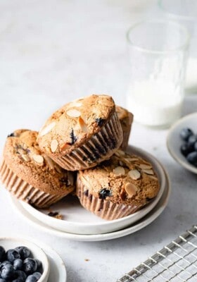 Side view of three paleo blueberry muffins on a white plate
