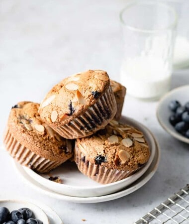 Side view of three paleo blueberry muffins on a white plate