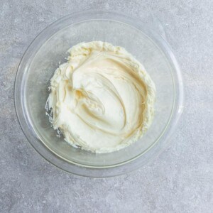 Dairy-free cream cheese frosting inside of a glass bowl on a granite surface