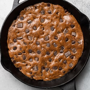 A cast-iron skillet with chocolate chip cookie dough pressed inside