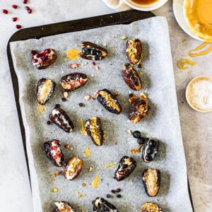 Top view of scattered traditional stuffed dates on a baking sheet