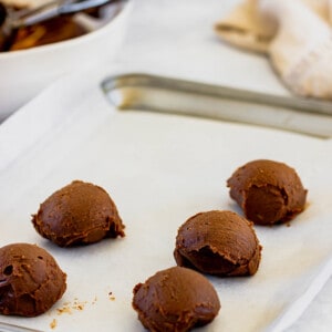 Chocolate truffle filling balls on a parchment-lined baking sheet