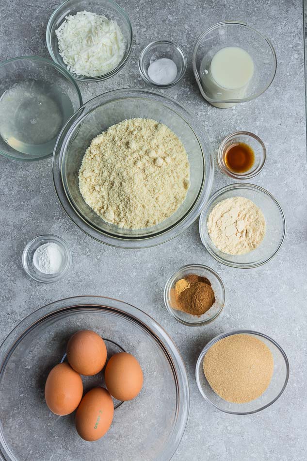 Top view of baking ingredients in glass bowls on grey surface.