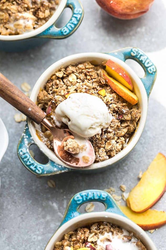 Overhead image of peach crisp in blue bowl with ice cream.