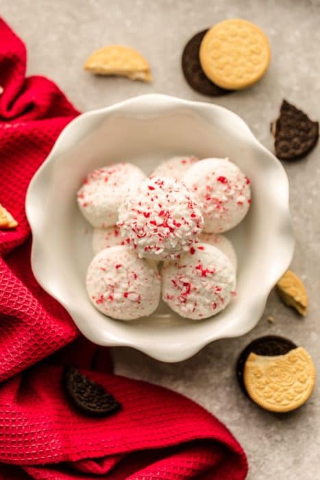 Peppermint Covered Oreos are the perfect festive and easy treat for the holidays. Vanilla or chocolate Oreo cookies are coated in white chocolate candy melts and crushed candy canes.