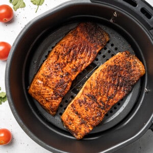 Two air fried salmon fillets in an air fryer basket