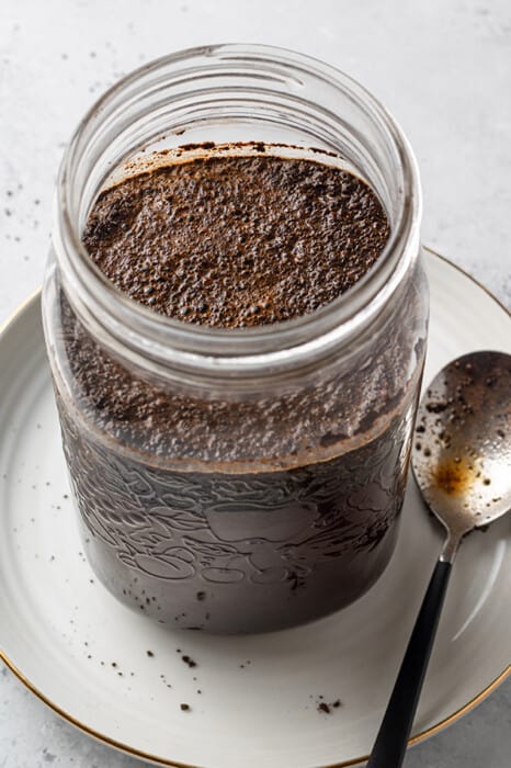 Steeped coffee grounds in a mason jar with water
