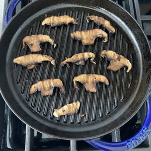 Cooked portobello mushroom slices on blue grill pan