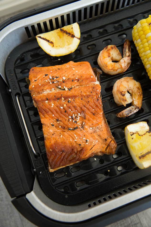 Close-up view of shrimp, salmon, lemon and corn in a Power Smokeless Grill