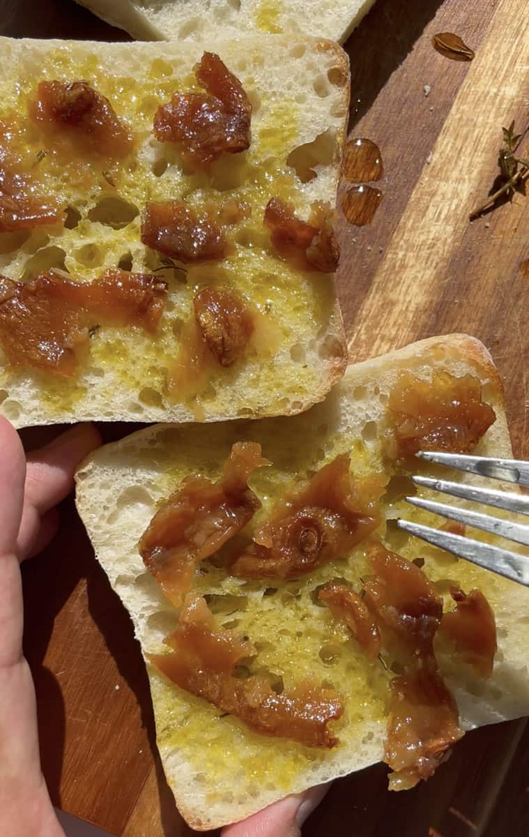 Mashed roasted garlic spread on two pieces of toasted ciabatta bread