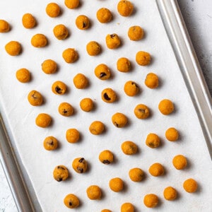 Cookie dough balls on a parchment-lined baking sheet