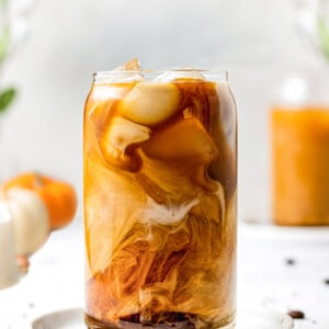 Side angle of one iced pumpkin cold brew coffee in a glass