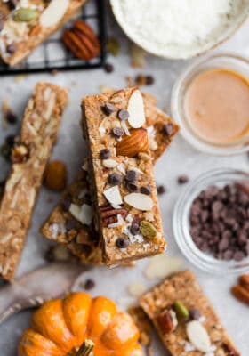 Close up top view of stacked pumpkin granola bars with chocolate chips on a grey background