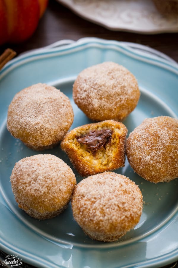 Pumpkin Nutella Donut Muffins on a plate with a bite out of one in the middle