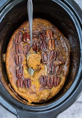 An entire baked pumpkin pecan cake in a black slow cooker