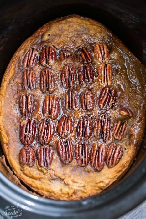 An entire baked pumpkin pecan cake in a black slow cooker