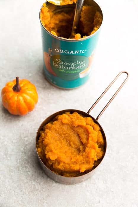 Top view of an opened can of organic pumpkin puree on a grey background
