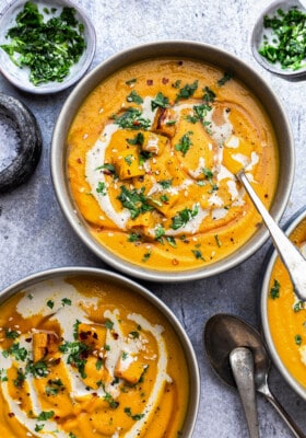 Top view of three pumpkin soup in a white bowl with a spoon