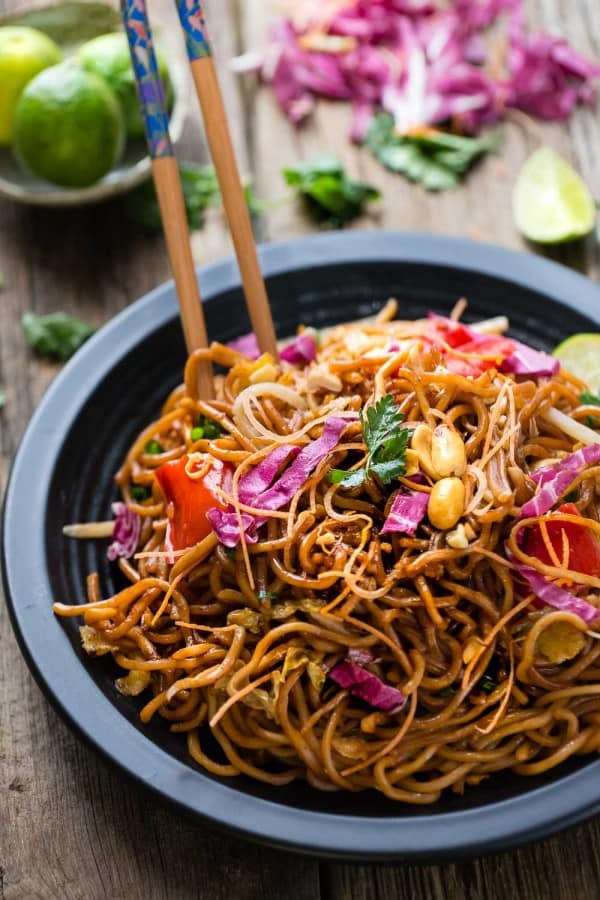 bowl of lo mein noodles with peanut sauce and healthy veggies mixed in