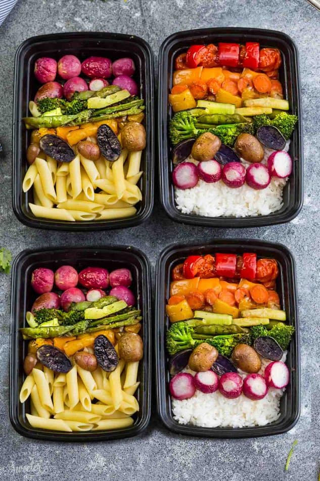 Top view of four meal prep containers of Rainbow Roasted Vegetables with rice and pasta