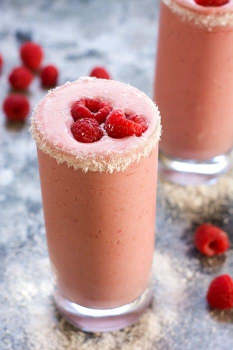 Raspberry Colada Smoothie in a glass topped with raspberries