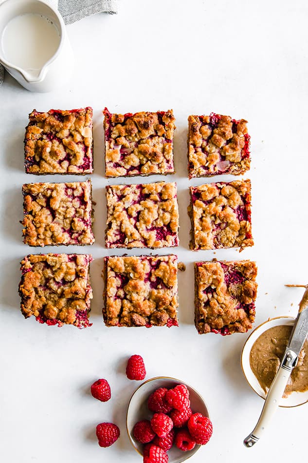 Top view of 9 raspberry pie bars on on a white background
