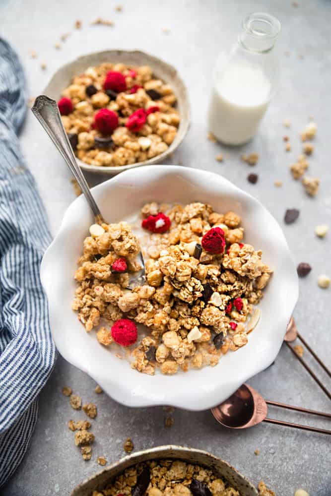 Raspberry Double Chocolate Granola makes the perfect gluten free breakfast or after school / pre or post workout snack. Loaded with crunchy clusters, shredded coconut, white and dark chocolate chips along with freeze-dried and fresh raspberries. Best of all, this recipe is gluten free and refined sugar free and works great for Sunday meal prep.