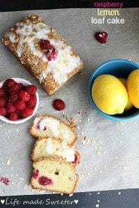 Overhead view of raspberry lemon loaf cake with a few slices cut and bowls of raspberries and lemons nearby