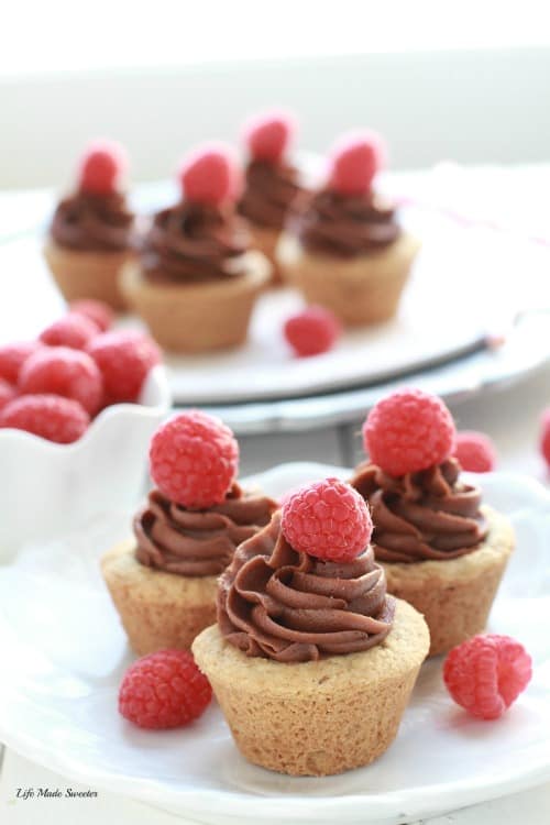 Raspberry Nutella Cookie Cups - A soft and chewy cookie dough base is filled with a sweet raspberry jam and topped with a decadent, Nutella cream cheese frosting.