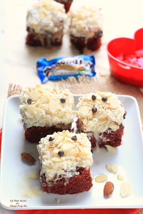 Overhead view of three Red Velvet Almond Joy Gooey Cake Bars on a plate