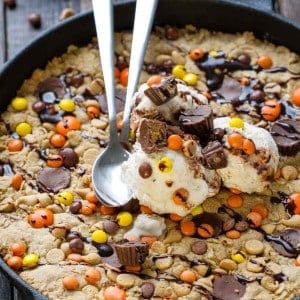 Reese's Peanut Butter Skillet Cookie topped with ice cream and two spoons