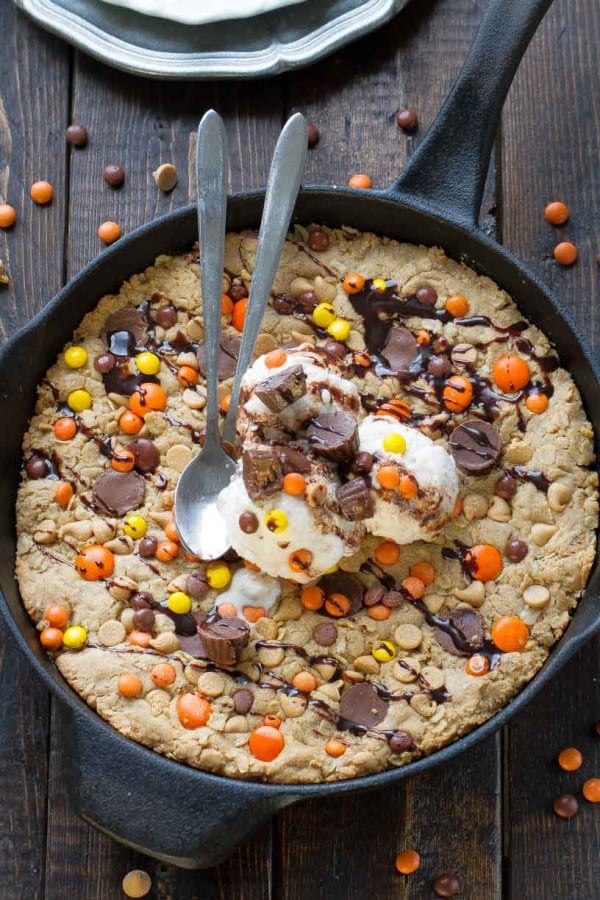 Overhead view of Reese's Peanut Butter Skillet Cookie topped with ice cream and two spoons