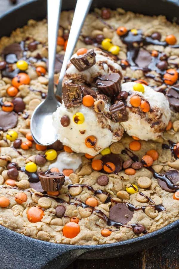 Close-up of Reese's Peanut Butter Skillet Cookie topped with ice cream and two spoons