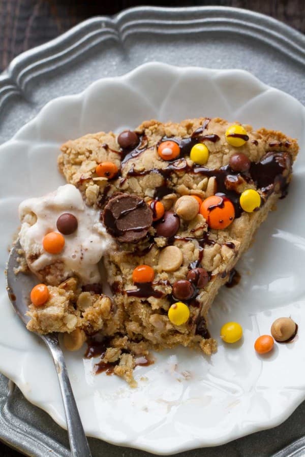 A slice of Reese's Peanut Butter Skillet Cookie with ice cream on a plate