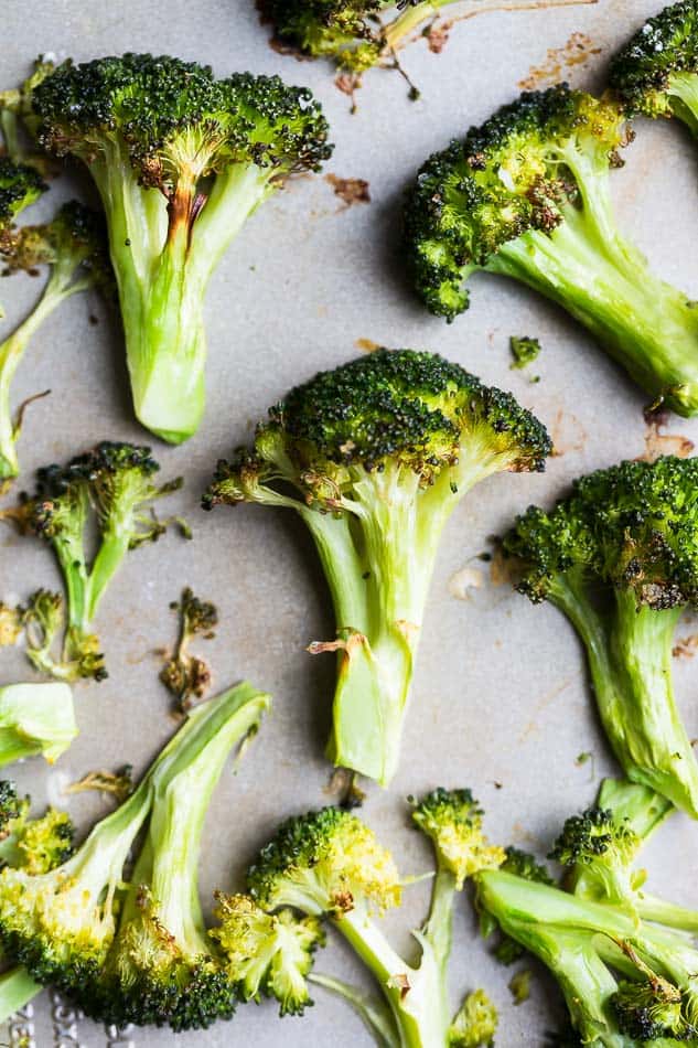 Overhead view of roasted broccoli on baking sheet.