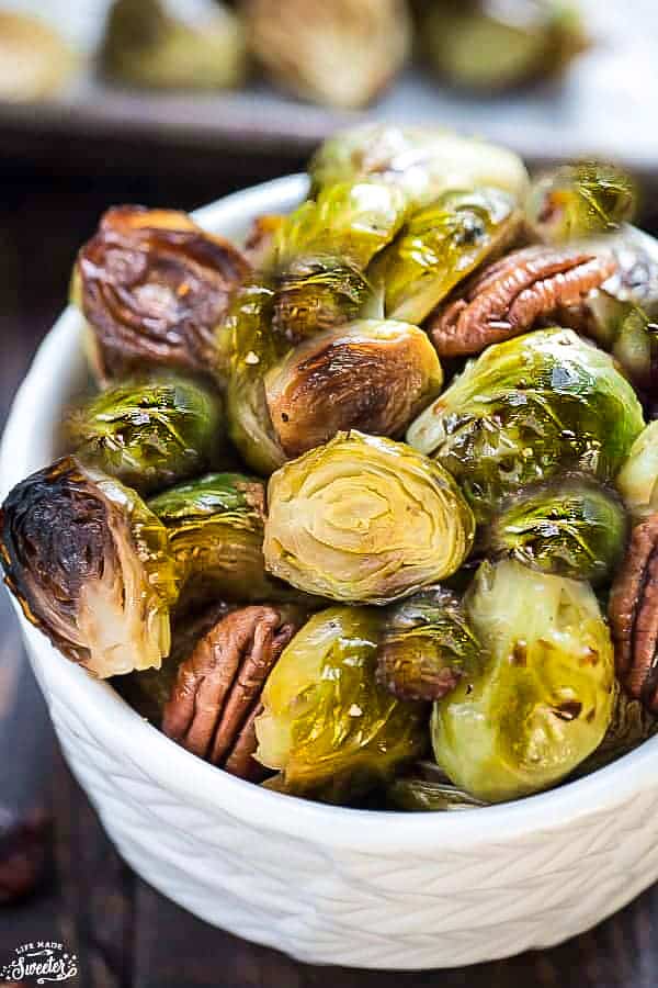 Roasted Brussels sprouts in a white bowl with pecans