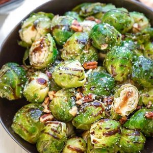 Roasted Brussels sprouts in a white bowl with parmesan and balsamic vinegar