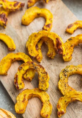 Top view of roasted delicata squash on a wooden cutting board