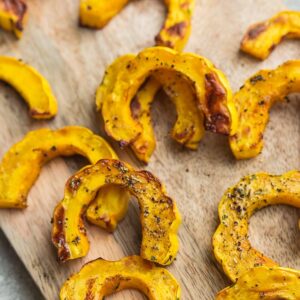 Top view of roasted delicata squash on a wooden cutting board