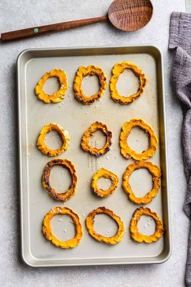 Roasted delicata rings on a baking sheet