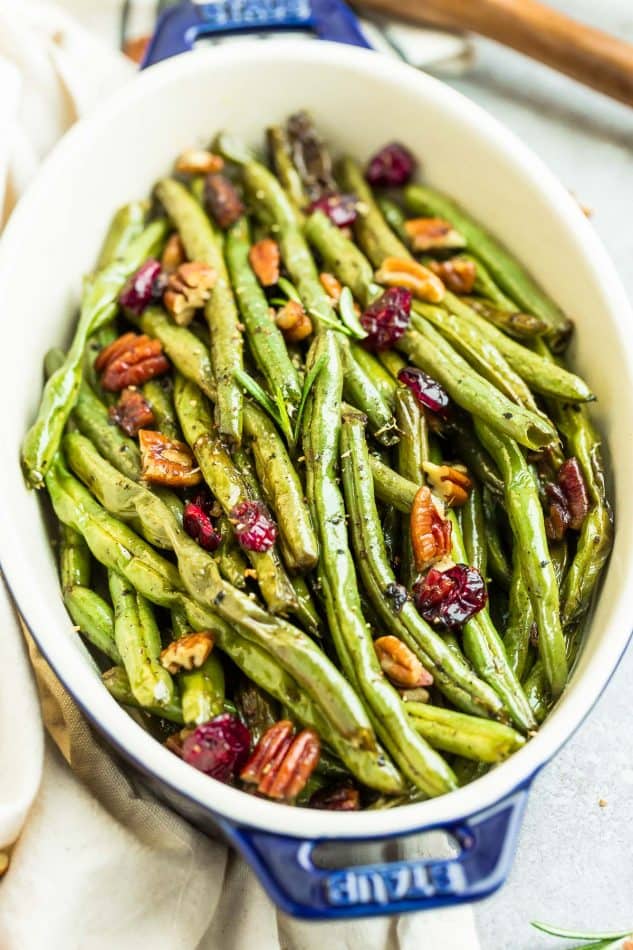 Roasted Green Beans with garlic, balsamic, lemon pepper pecans (and optional cranberries) is the perfect simple recipe to enjoy fresh green beans. This recipe is fancy enough for Thanksgiving, Christmas, or Easter holiday meal, and easy enough for a weeknight side dish! #sidedish #Thanksgiving #christmas #healthy #balsamic #garlic #roasted #vegetables #healthy #keto #paleo #lowcarb
