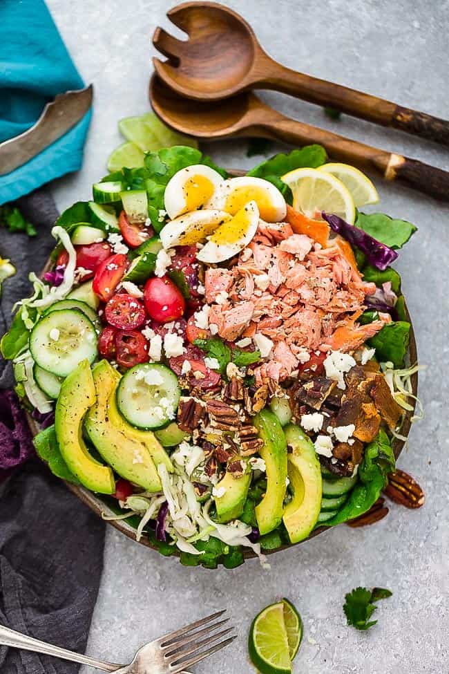 Salmon Cobb Salad is a lightened up twist on the classic Cobb Salad. It’s made with grilled or broiled salmon, cucumber, eggs, tomatoes, avocado, crispy bacon and a creamy and tangy vinaigrette. Low carb, keto , gluten free with Whole 30 & paleo friendly options.