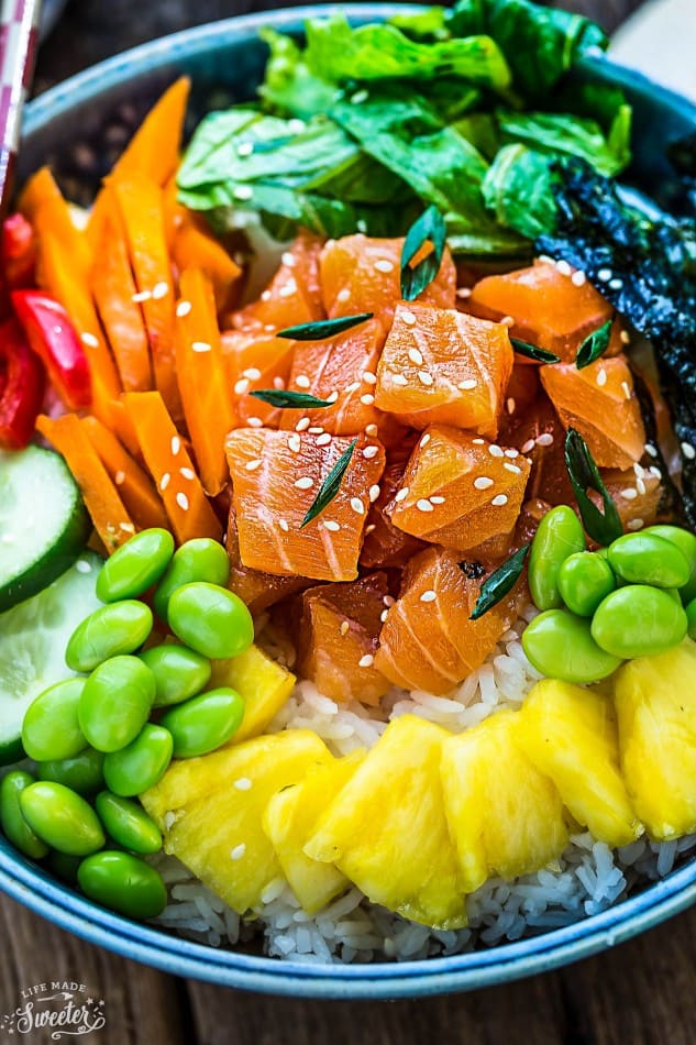 A close-up shot of a poke bowl topped with sesame seeds and shredded seaweed